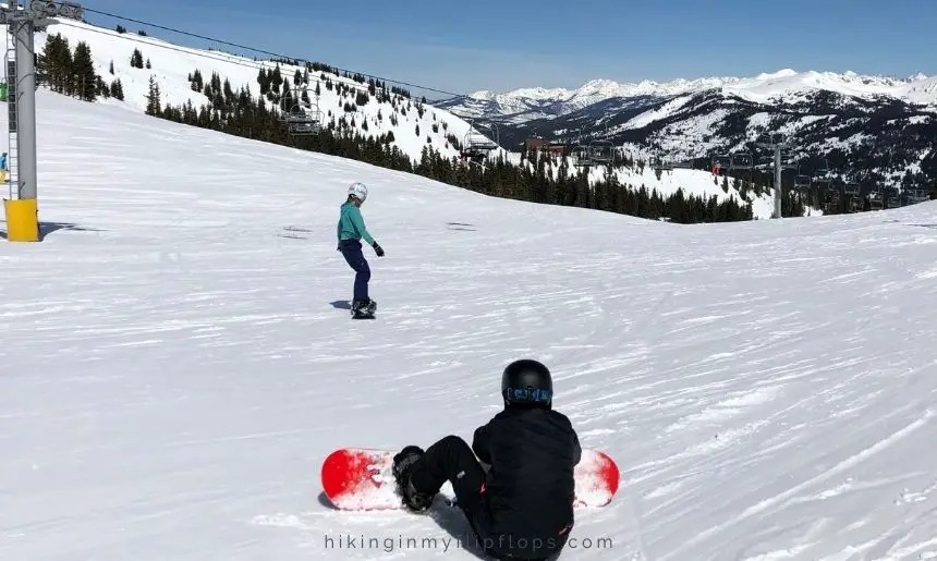 snowboarders at the top of a ski run 