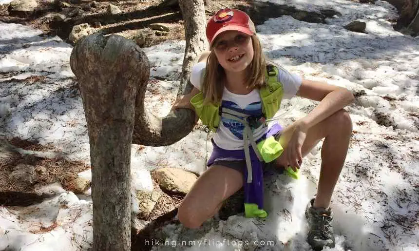 a girl next to a unique tree shows one of the ways we learned how to make hiking fun for kids