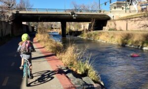 biking on the Cherry Creek Trail in Denver as it runs along the creek