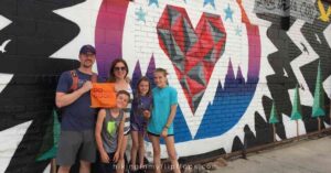 a family in front of a street mural in Denver, Colorado