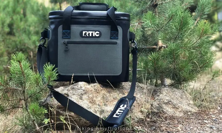 a soft-sided RTIC cooler placed on a rock at a campground used to keep food cold while camping