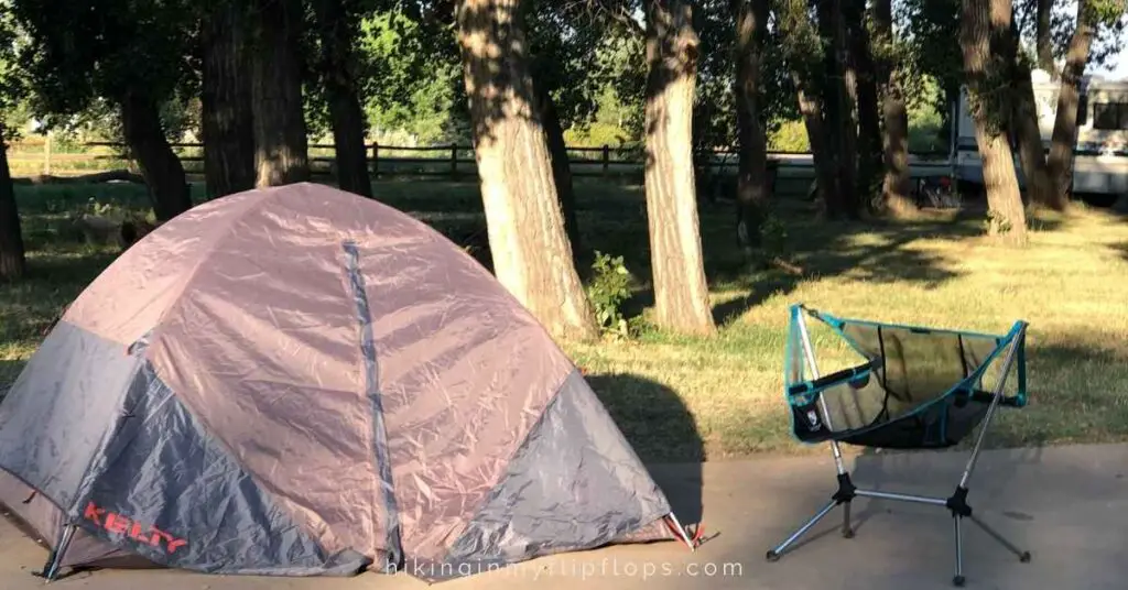 a tent and a camp chair at a campsite shows a good camping for beginners setup