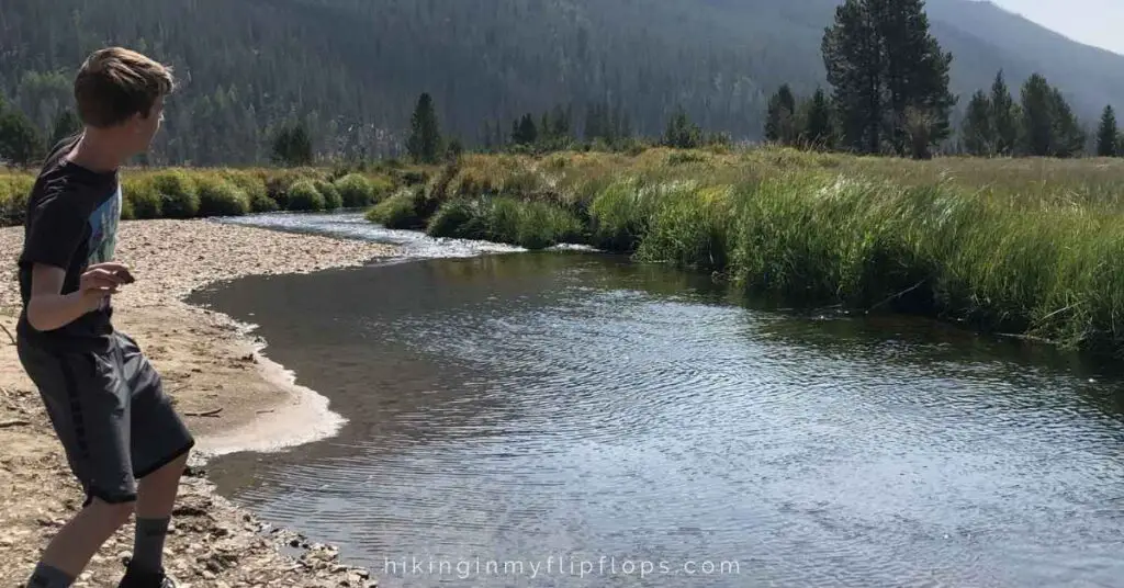 skipping rocks in the river, depicting one of the fun things to do when camping