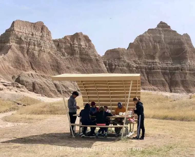 a family having a picnic at a covered table near the Ben Rifle Visitor Center in Badlands National Park