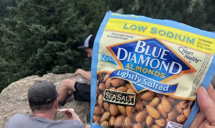 a hiker holding a bag of almonds, depicting the best snacks for hiking
