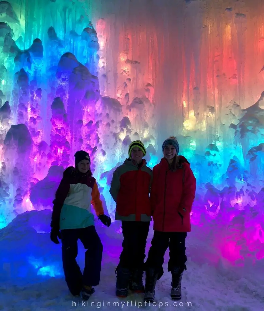 kids in the Dillon Ice Castles with a backdrop of color-changing lights