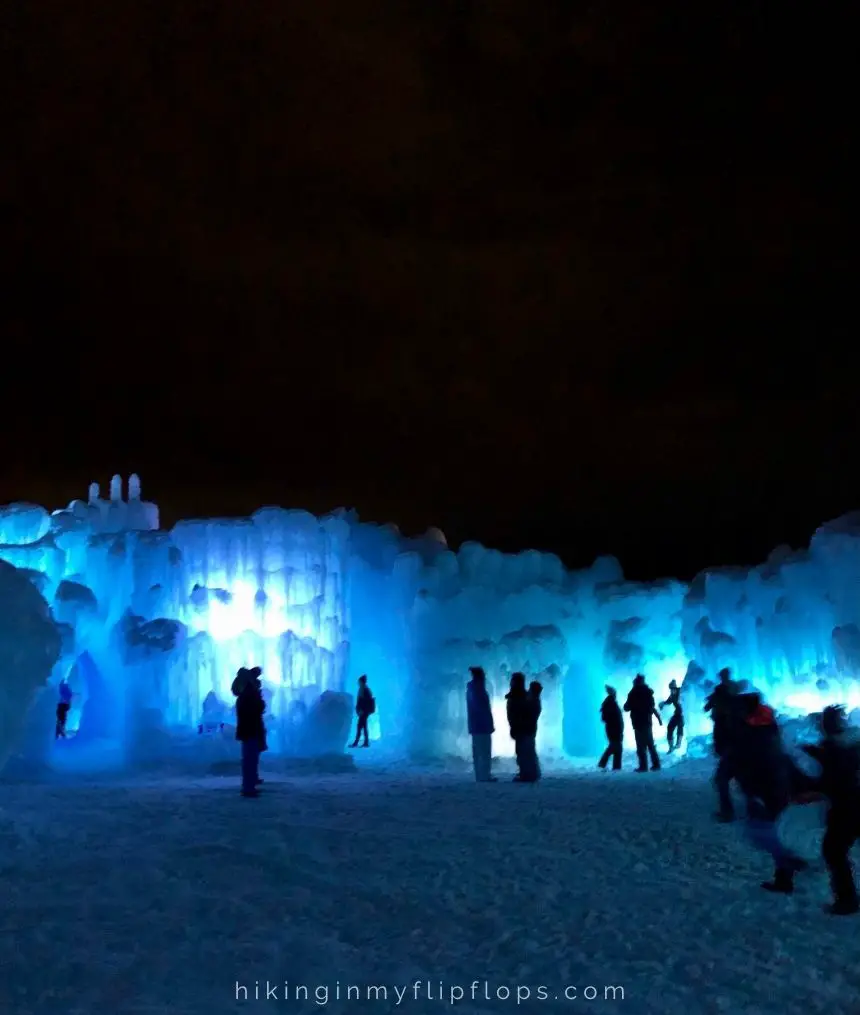 the silhouettes of people with the glow of lights from inside the Dillon Ice Castles