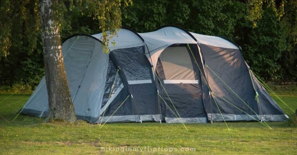 a camping tent set up by a tree that is one of the best large tents for family camping