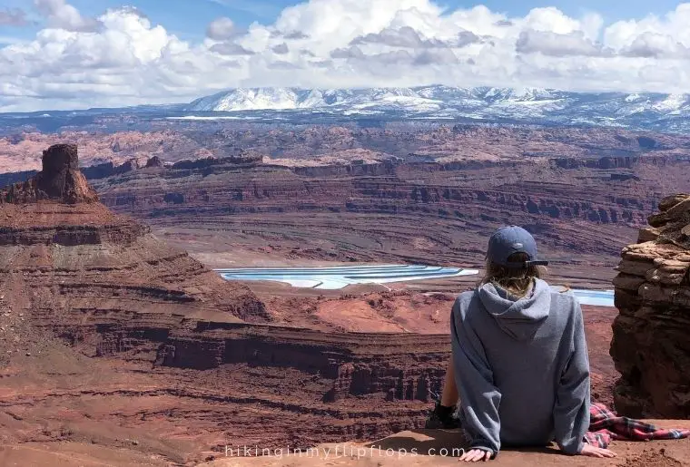 a girl taking in the view of the evaporation pools from the East Rim of Dead Horse Point State Park