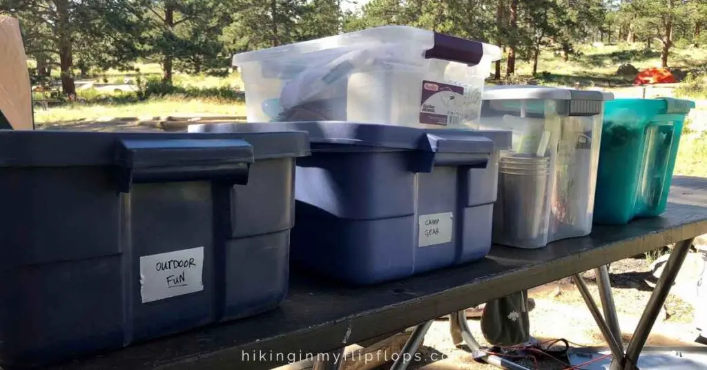 totes packed with camping gear on a picnic table holds everything on the family camping checklist