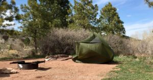 a camping tent blown over from wind shows improvising to avoid one of the common camping mistakes