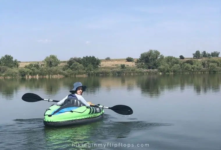 a girl in an inflatable kayak, showing one of the things to do while camping