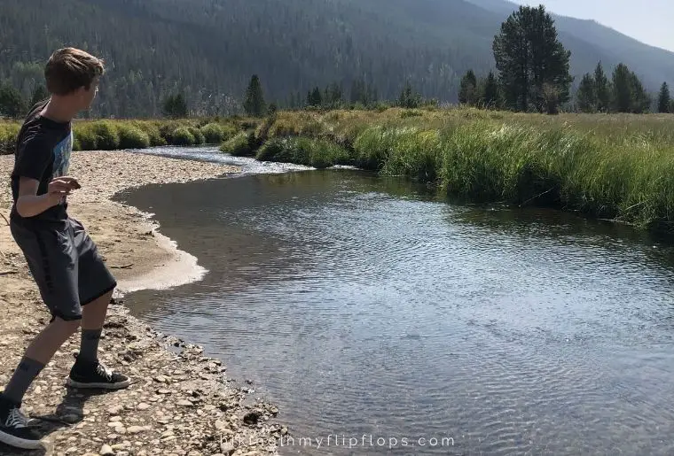 a boy skipping stones in a river