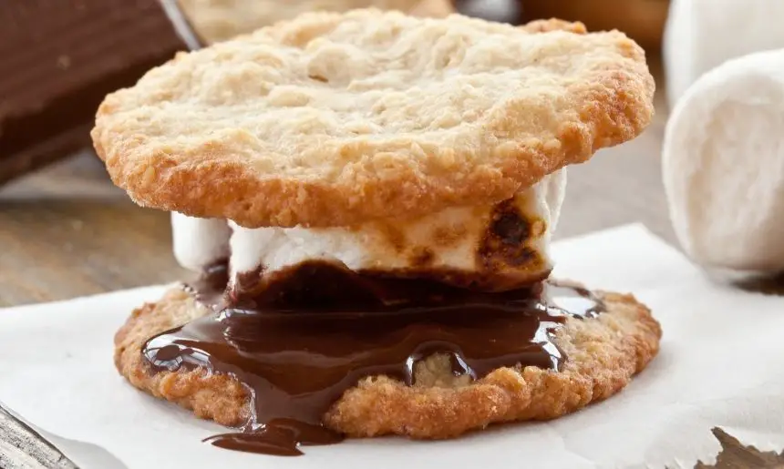 a s'more using cookies in place of graham crackers, showing s'mores ideas for camping