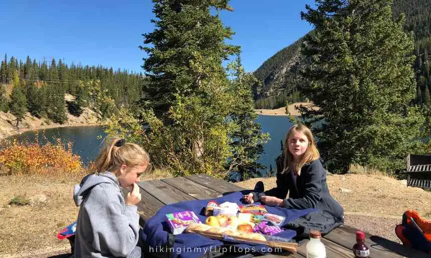 girls having lunch at a picnic table with their favorite road trip foods