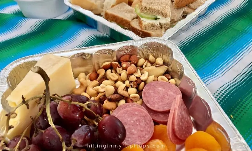 a road trip food list with meats, cheeses, nuts, and fruit can be used for snack boards on the road