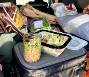 mason jar and pasta salads served from the back of an SUV on a road trip