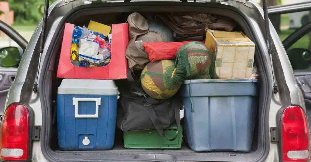 the back of an SUV filled with totes and gear when packing a car for camping