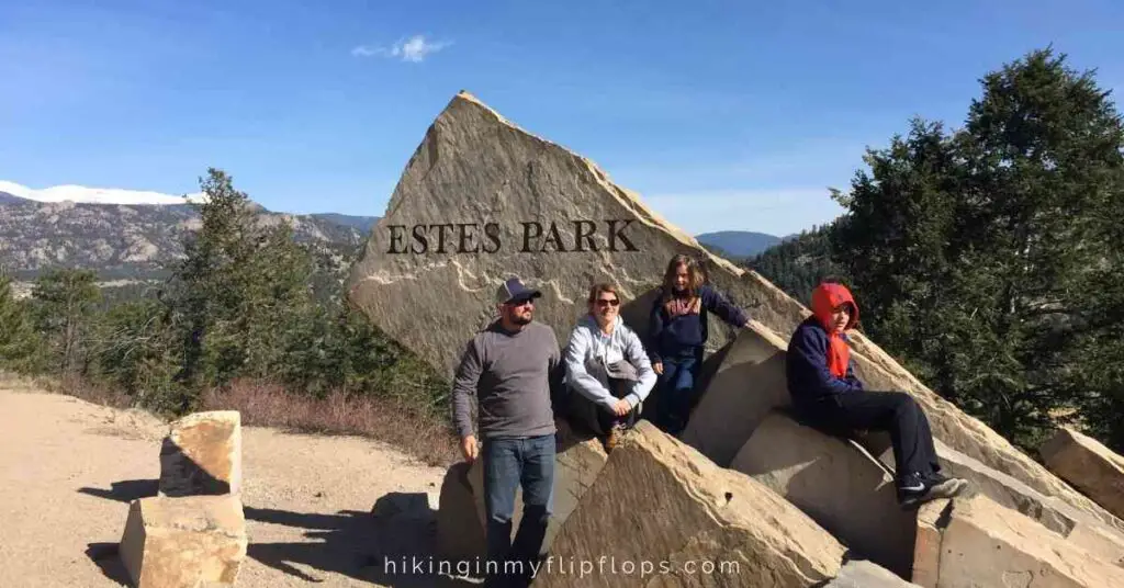 a family in front of the entrance to Estes Park, Colorado