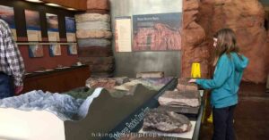 a girl exploring a rock exhibit at arches np visitor center at