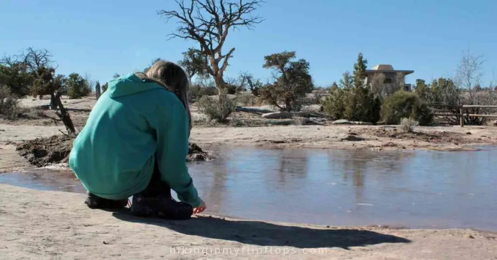 a girl looking in the small ponds at Canyonlands NP