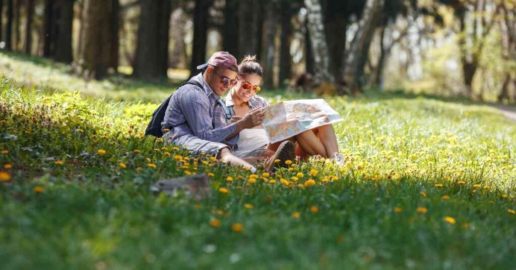 a couple looking at a map in a grassy field