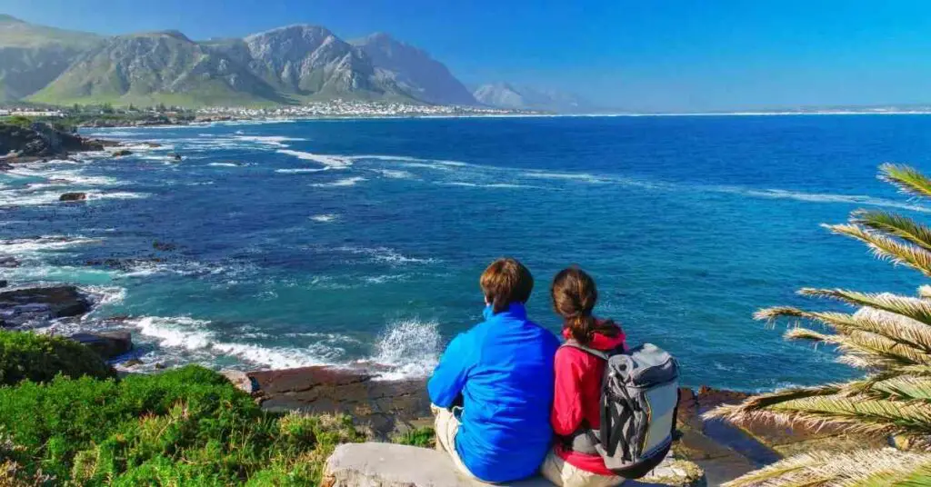 a couple taking in the view of the ocean and mountain depicting hiking date ideas
