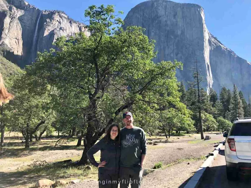 a couple standing in front of the half dome in Yosemite NP 
