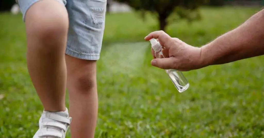 a child getting sprayed with a homemade bug repellent showing how to repel mosquitoes while camping