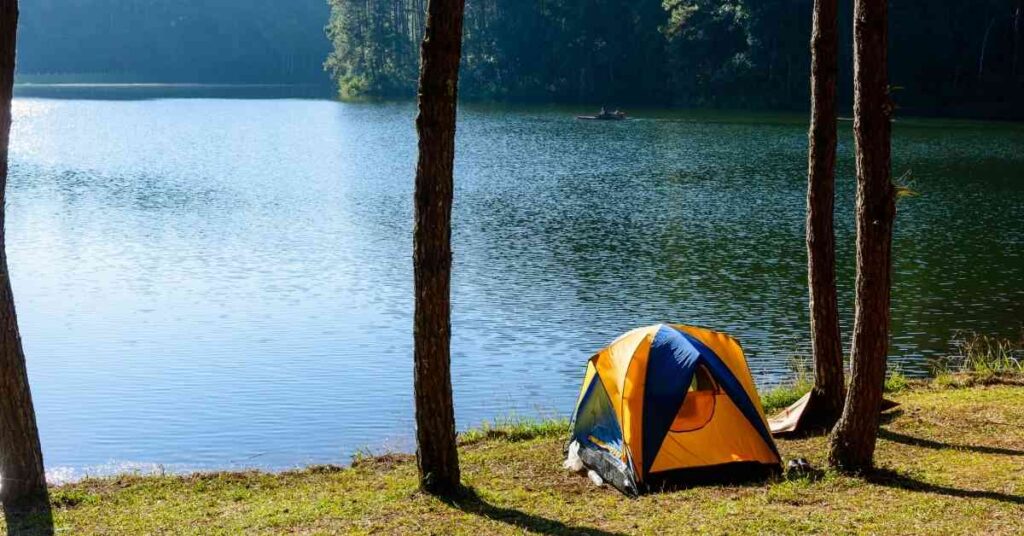 a tent set up for camping by a lake