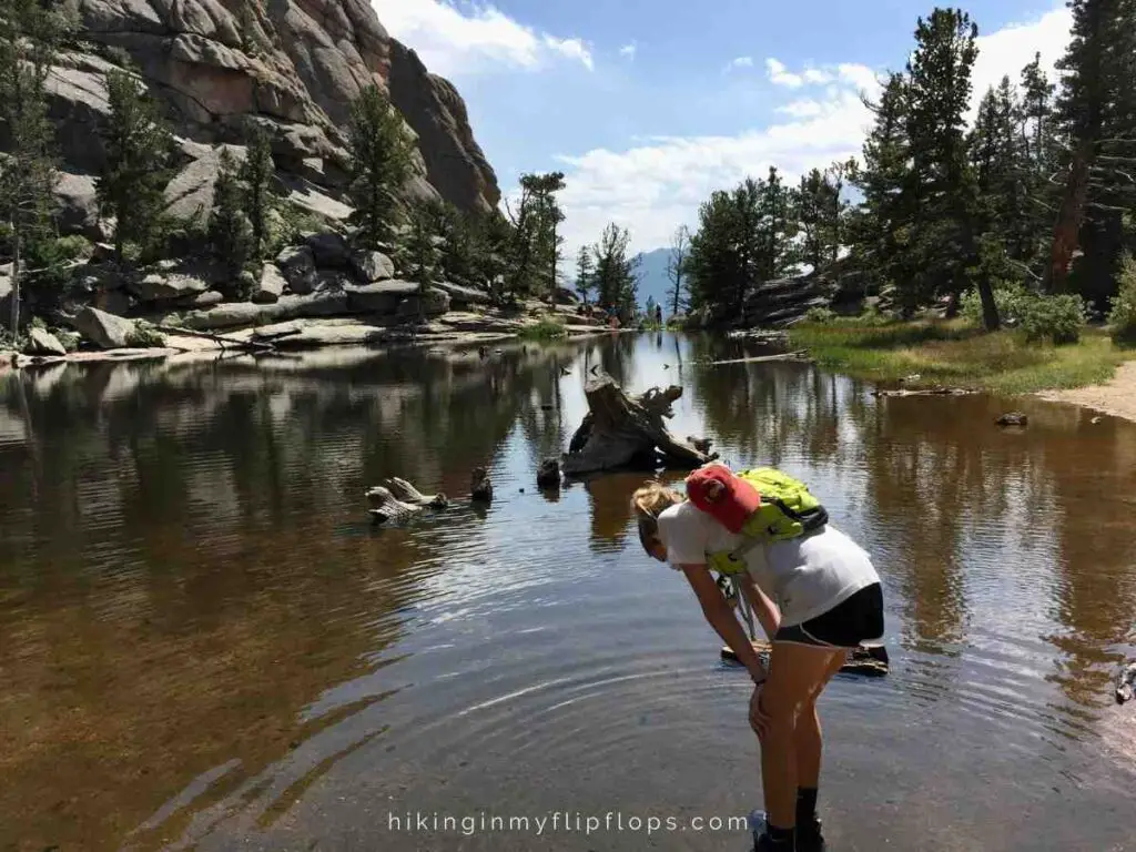 a girl looking into the water at Gem Lake in Rocky Mountain NP