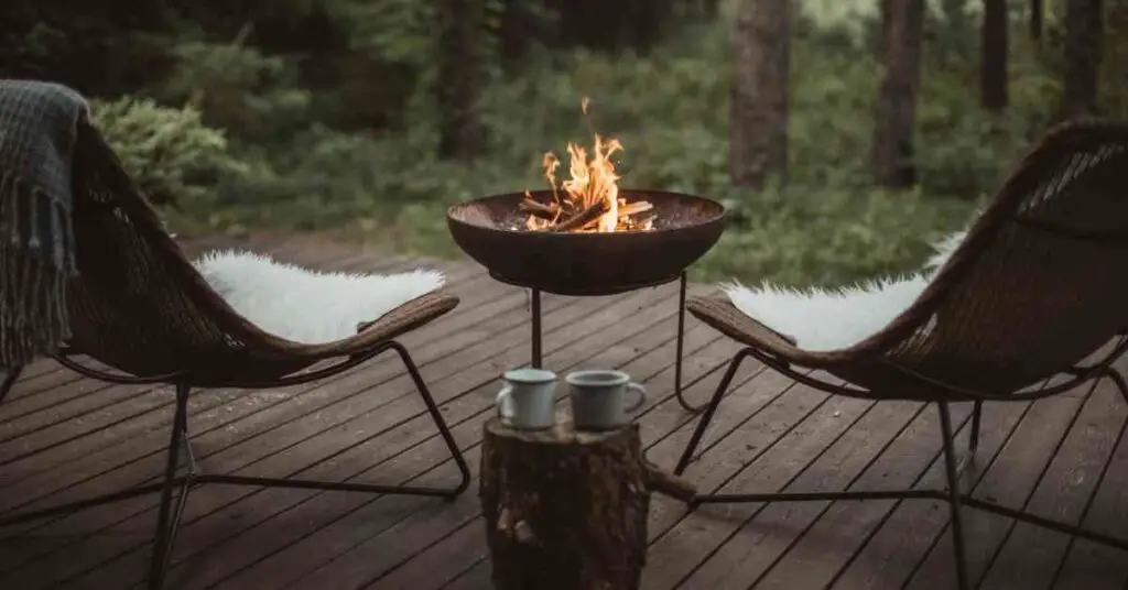 two chairs set up next to a fire in a portable fire pit