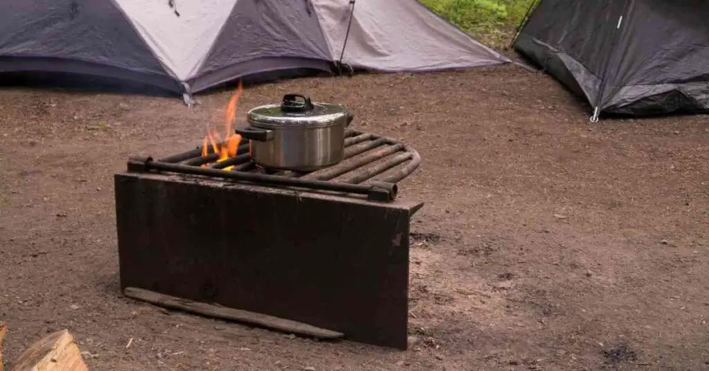 a pot set on the grill grate over a campfire