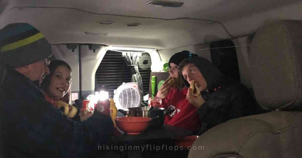a family sitting around the convertible dining table in a campervan