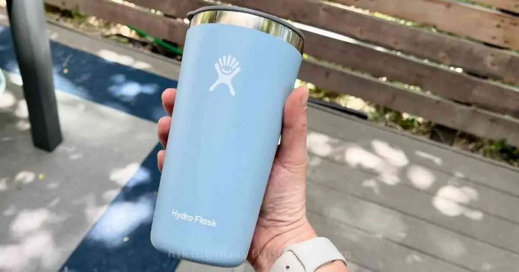 a person holding a light blue Hydro Flask tumbler for a comparison of the best insulated tumbler