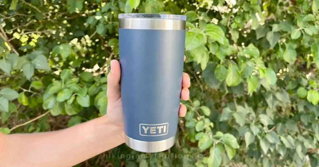 a person holding a darker blue Yeti Rambler for comparing the RTIC vs yeti tumbler