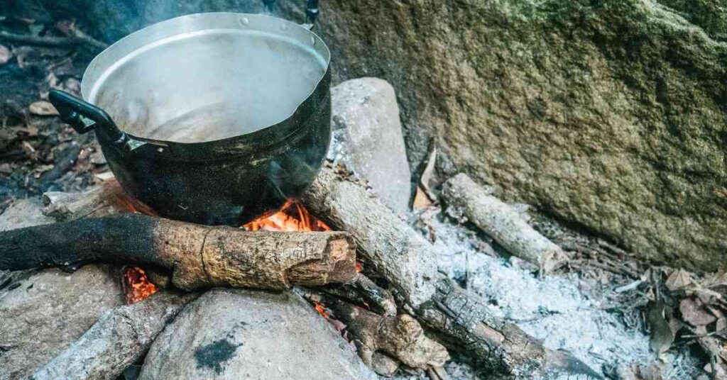 a pot of water over a campfire