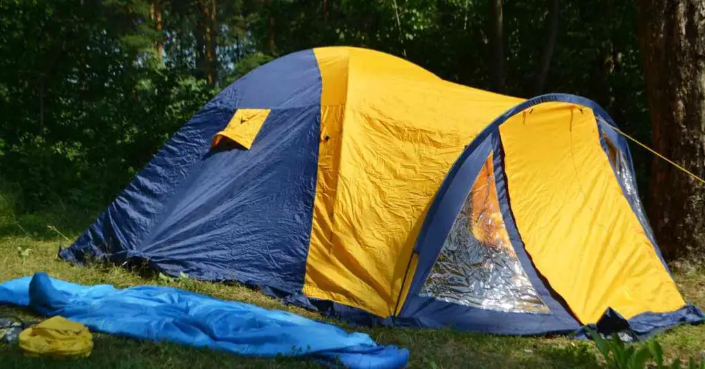 a yellow tent set up showing an example of a modified dome, one of the types of camping tents